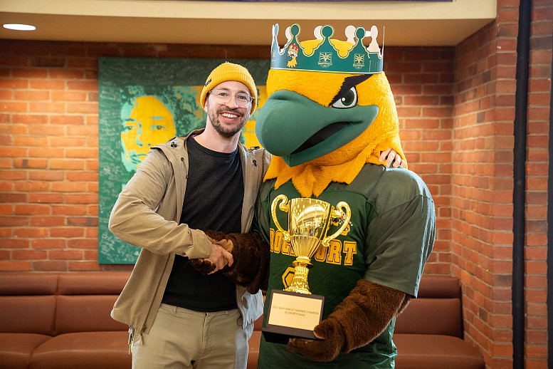 Ellsworth posing with his trophy while shaking a man's hand