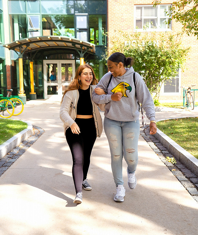 Two students walking down a walkway on campus