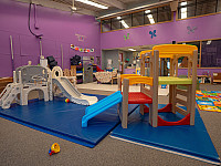 wide shot of a classroom with multiple slides and other climbing toys