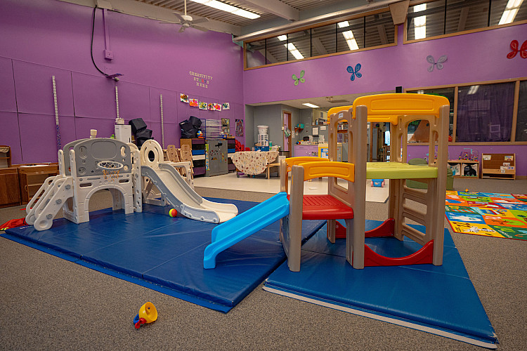 wide shot of a classroom with multiple slides and other climbing toys