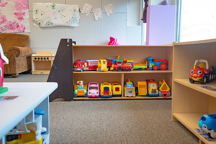 Toy cars, trucks, and trains on a shelf