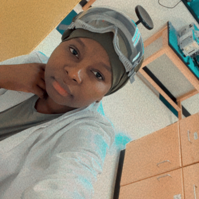 Selfie of Biba Sofiani dressed in lab gear in a lab