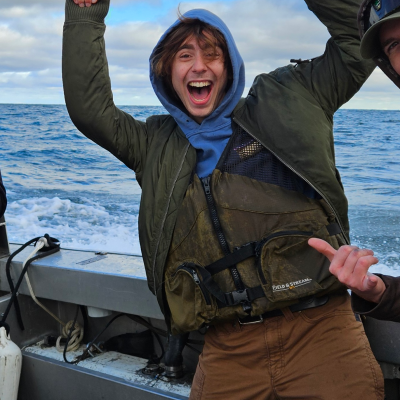 Zane Fermon playfully posing for the camera on a boat