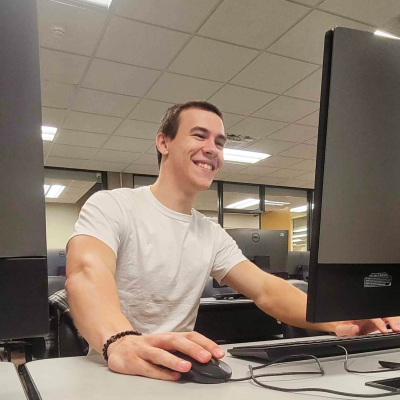 David Lonski smiling at a computer in a computer lab