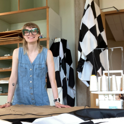 Sophia Berwanger in a workspace filled with fabrics and a sewing machine