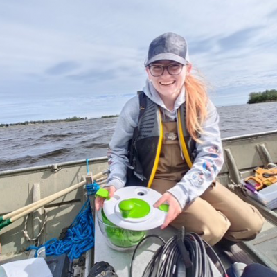 Juliana Smith in a boat with various field instruments