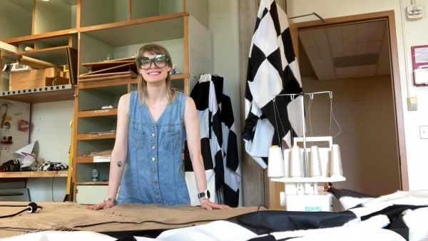 Sophia Berwanger in a workspace filled with fabrics and a sewing machine
