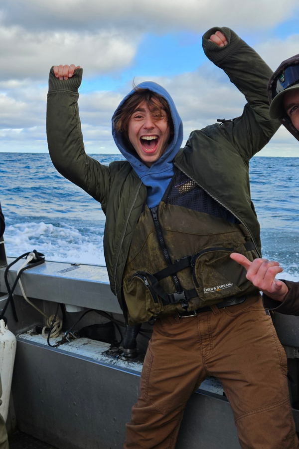 Zane Fermon playfully posing for the camera on a boat