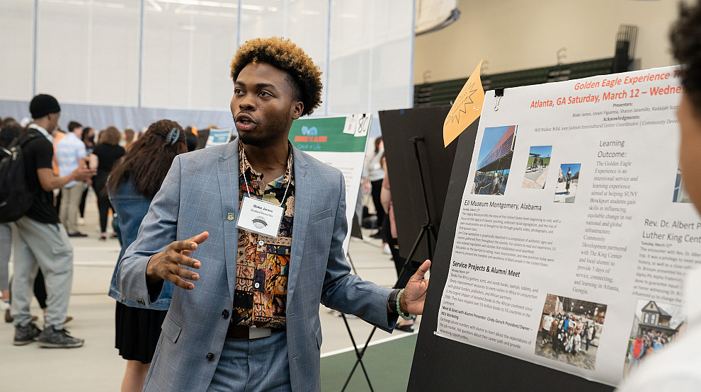 Student presenting their poster on Scholars Day in the Special Events and Recreation Center.