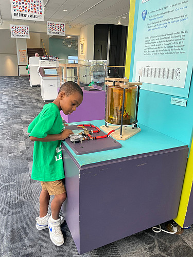 Brockport Summer Learning student interacting with an interactive exhibit at the Rochester Museum and Science Center