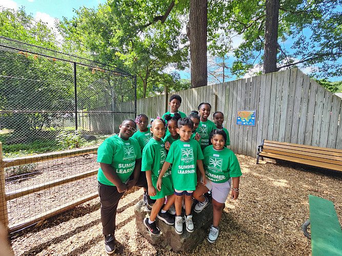 Brockport Summer Learning students posing for a group photo in front of an animal exhibit at the Seneca Park Zoo.