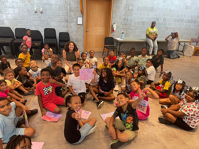Group photo of Brockport Summer Learning staff and students sitting on the floor.