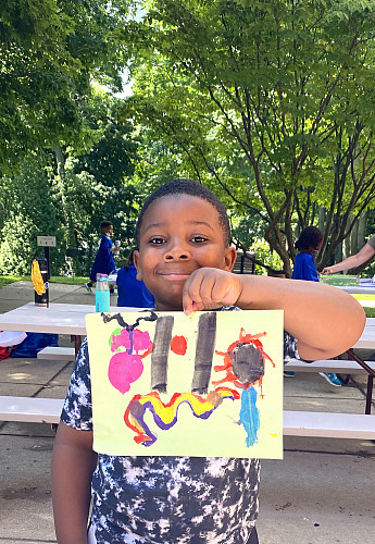 A child holding up their drawing