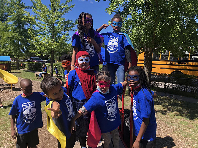 Group of children dressed up as superheroes posing for the camera at a playground
