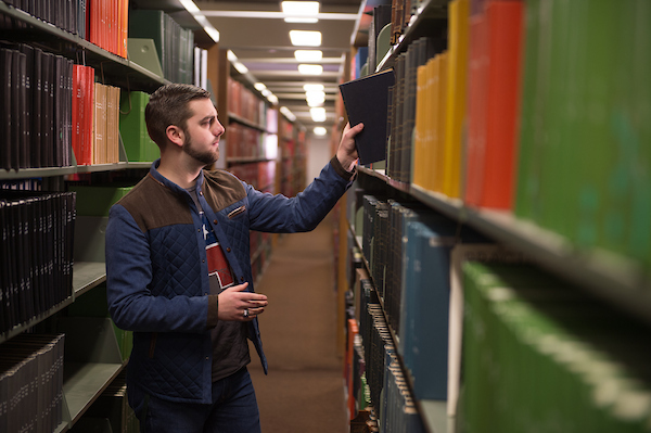 Student looking for a book in the Drake Library