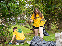 Two students picking up trash at local park