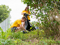 Two student volunteers picking up trash at a local playground