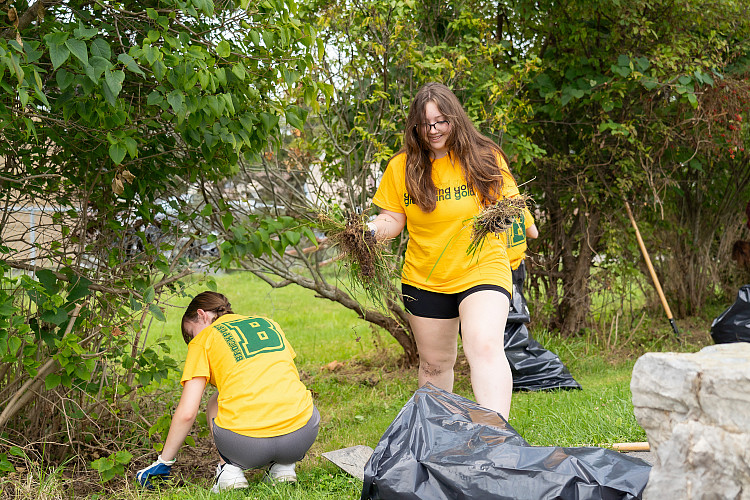 Two students picking up trash at local park
