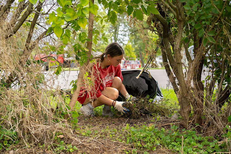 One student volunteer picking up trash at a local park