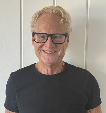 Headshot of alumni wearing glasses and dark shirt.