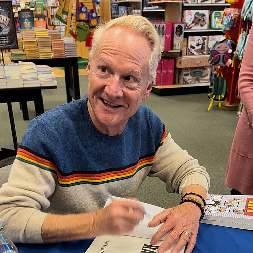 Man signing books at book signing.