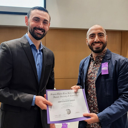Two men holding a certificate at ceremony.