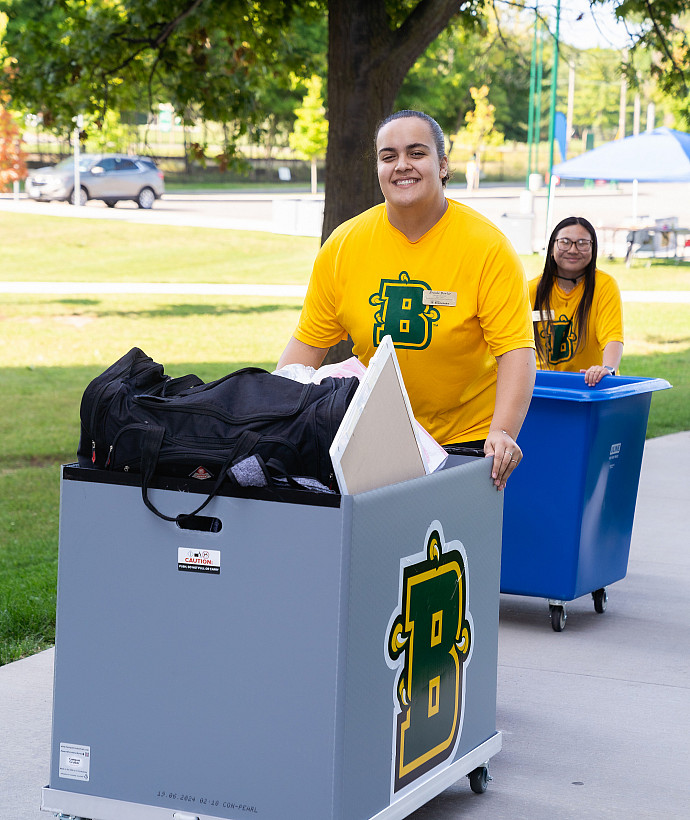 Person pushing cart, another person in background.