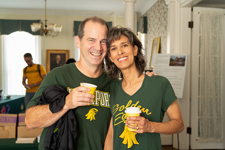 Two people smiling holding coffees