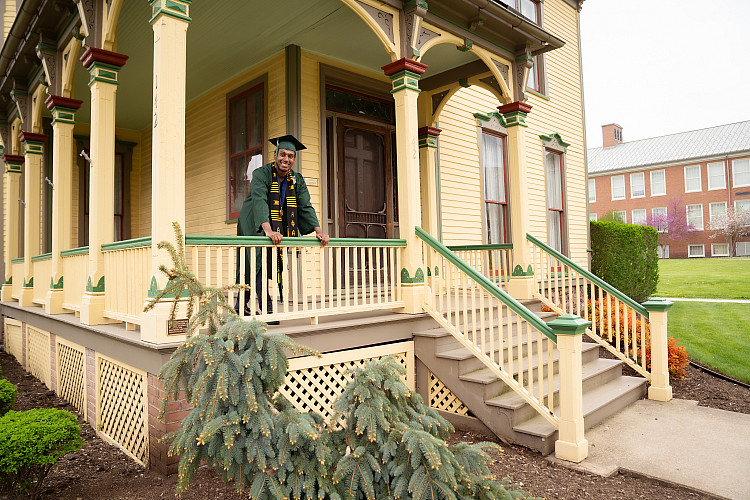 Brockport graduate on Alumni House porch