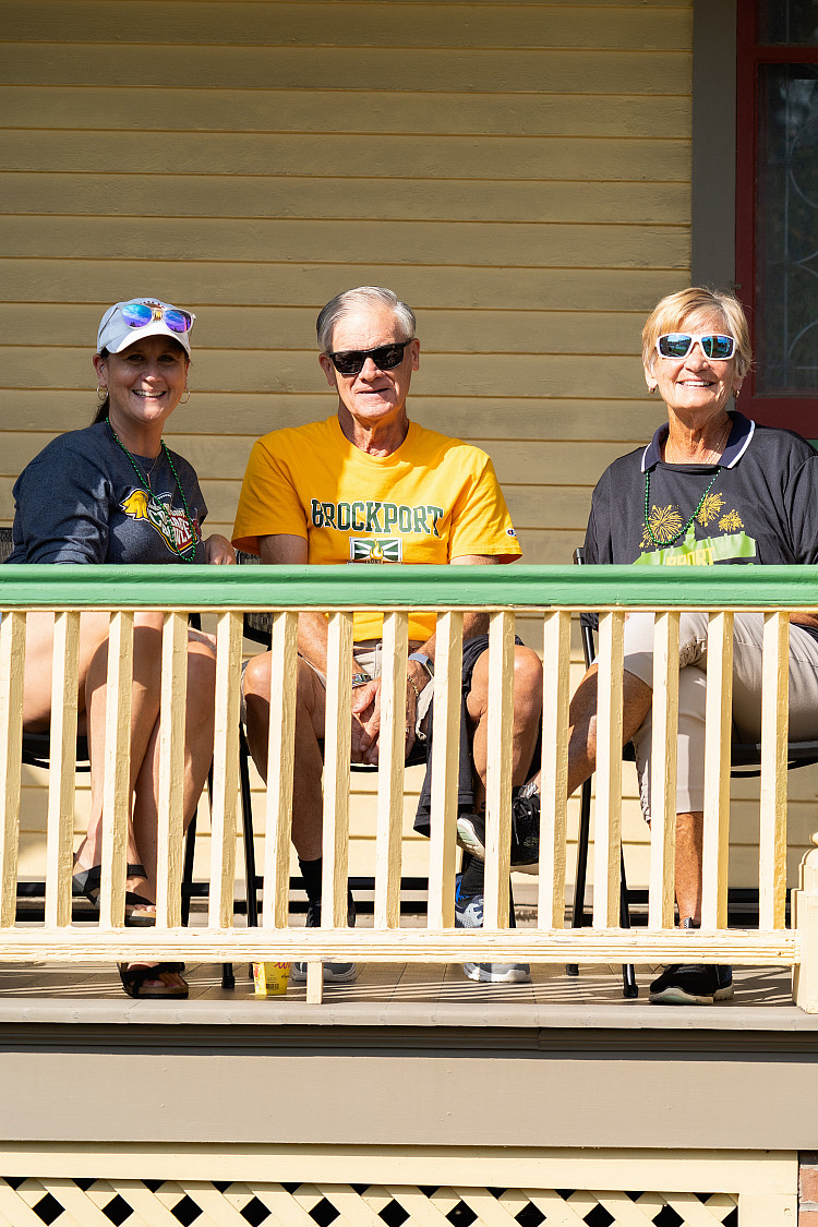 Three alums sitting on porch