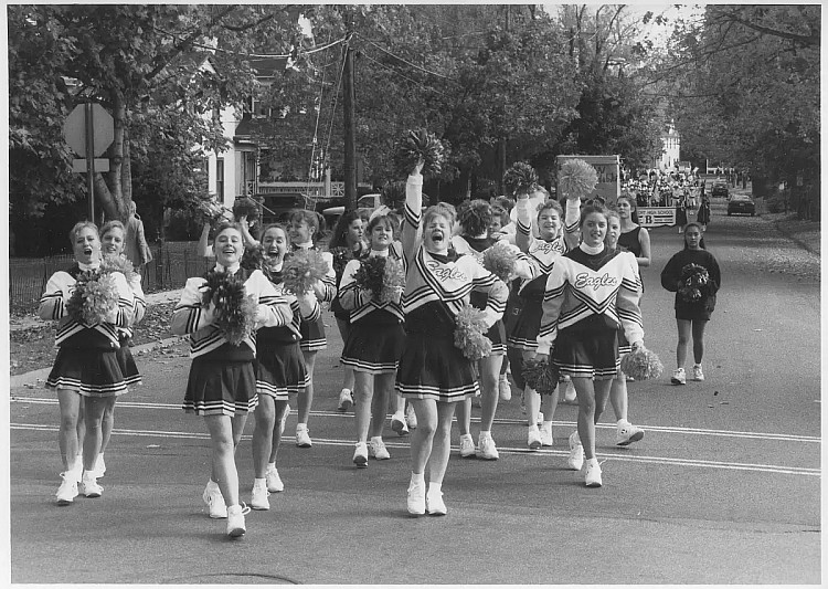 Black and white photo of cheerleaders in parade.
