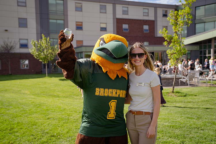 Woman standing with Ellsworth mascot.
