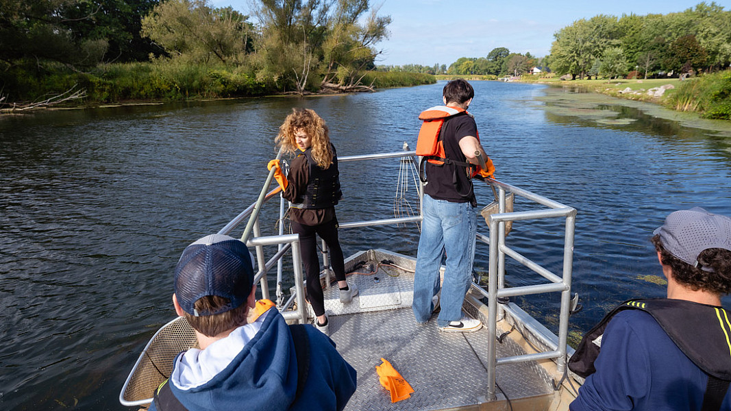 Students on a boat catching fish for research in Lake Ontario