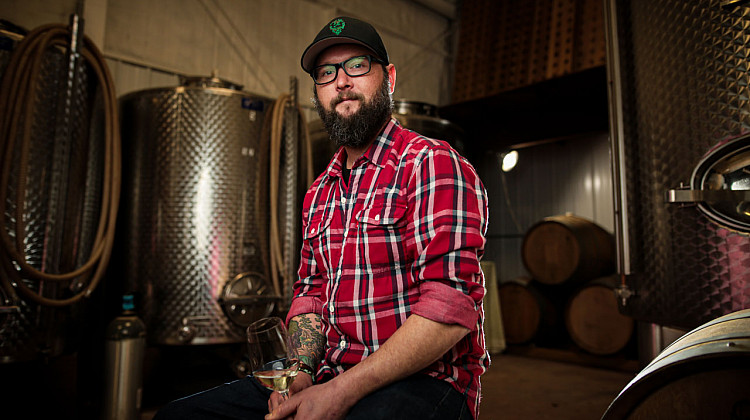 Nathan Kendall in his wine cellar holding a glass of wine