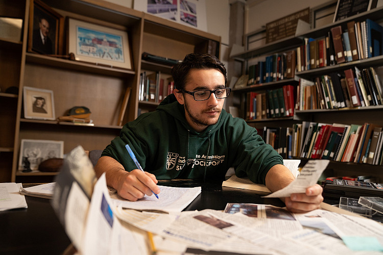 Student delving into the Rose Archives at Drake Memorial Library