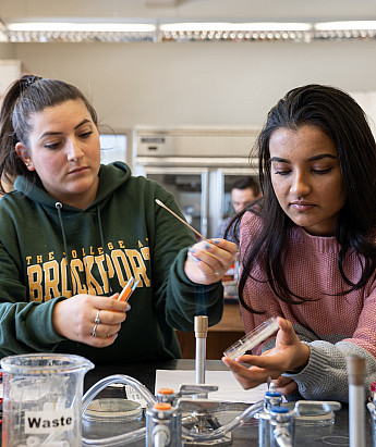 2 female Brockport students conducting an experiment in a biology lab