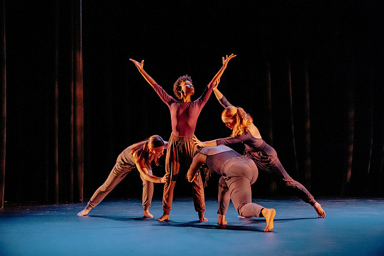 Four dancers performing on stage