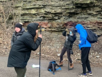 Geology students using measurement tools to measure rock layers