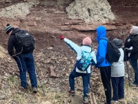 Geology students looking at a rock wall