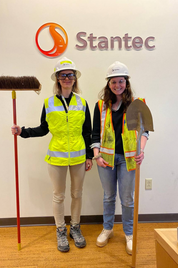 Christina Deluca (right) with Amanda Matkosky (left) in front of a Stantec sign