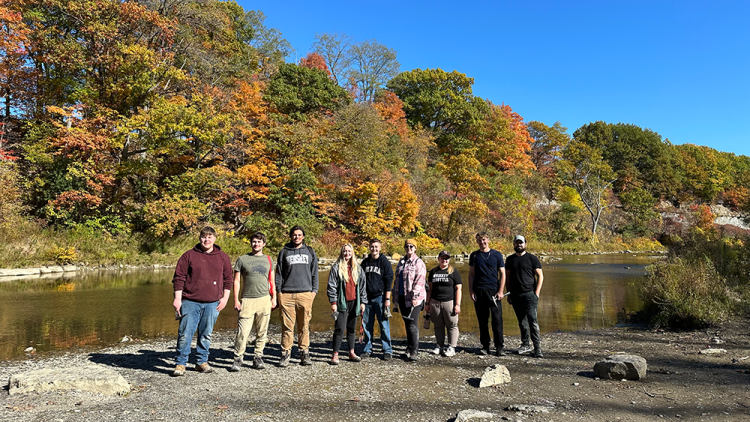 Earth Science students posing outside on a riverbed
