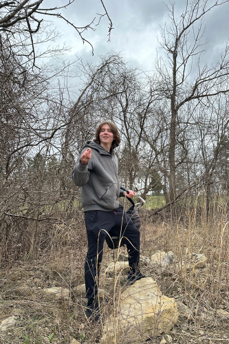 Earth Science student picking up a piece of broken rock