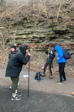 Geology students using measurement tools to measure rock layers