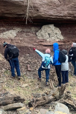 Geology students looking at a rock wall