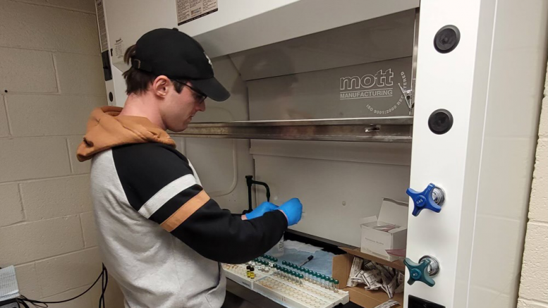Robbie Sullivan handling foam and water samples in a lab