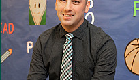 principal sits in front of children's artwork
