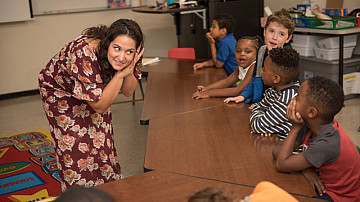 Student teacher listening to children in class