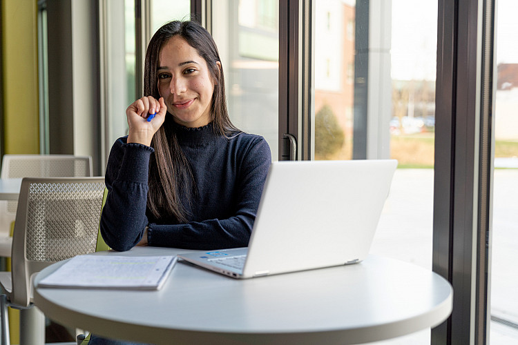 Student sitting at a desk with a laptop open