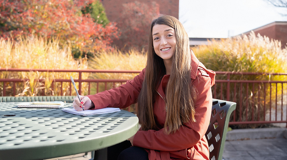 Graduate Student sitting at table outside of the Union