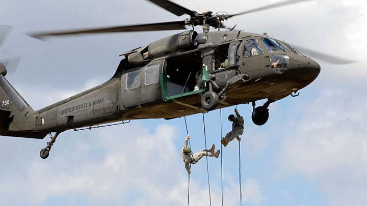 Two cadets rappelling down from a helicoptor